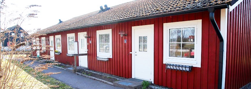 Rött hus med vita dörrar och fönster