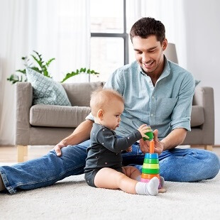 Pappa leker med dotter på vardagsrumsgolv